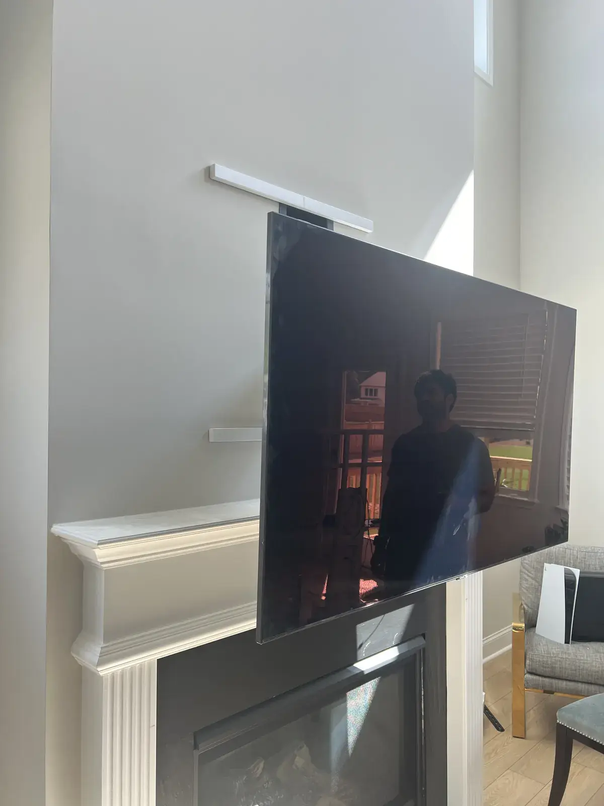 A TV on a full-motion arm swung out from a white wall beside crown molding