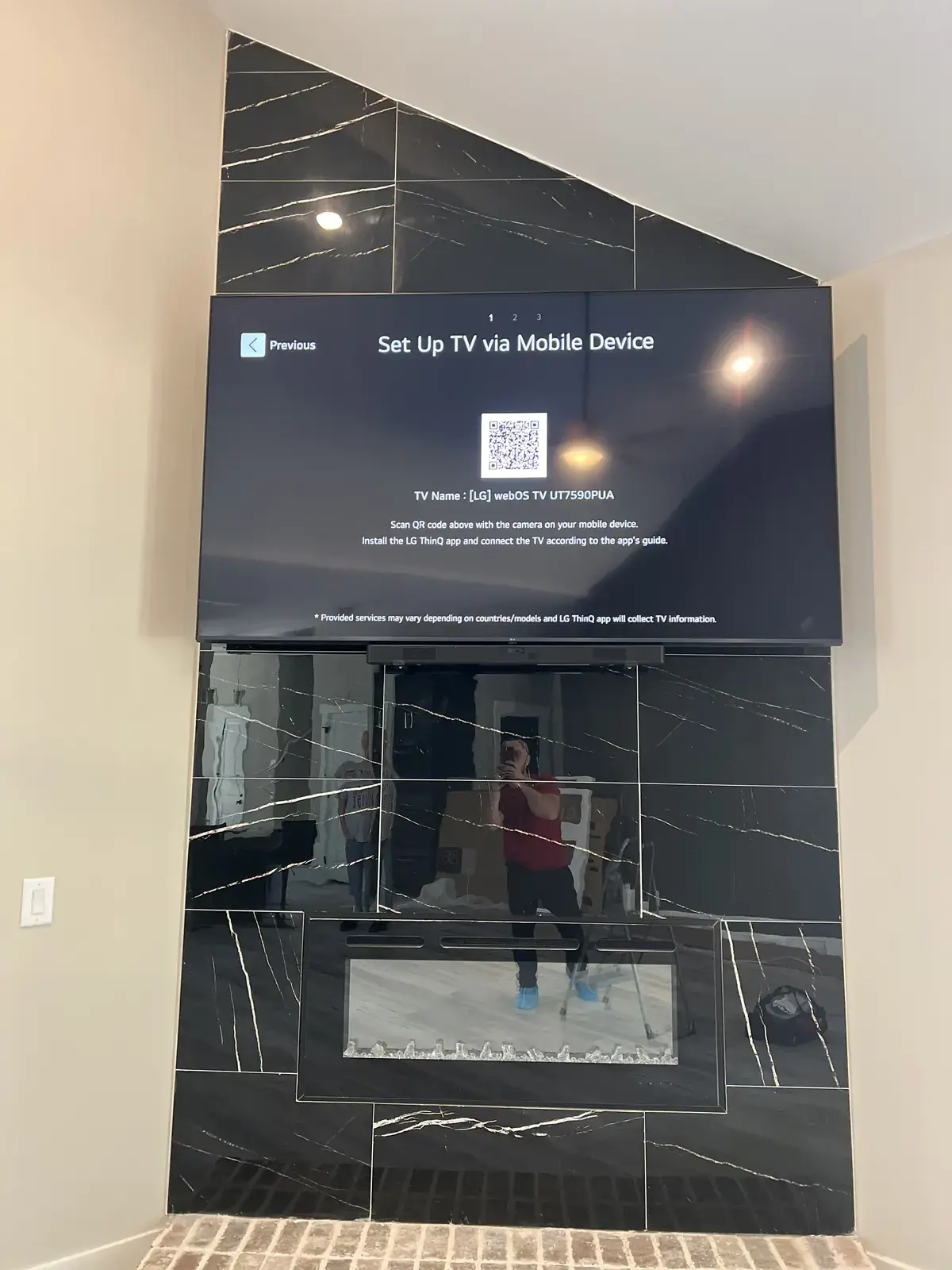 A TV set up on the full-motion mount on the black tile fireplace wall