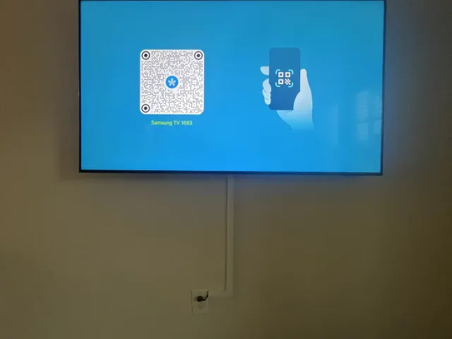 A TV on a tan wall with a paintable cable raceway running down to the outlet